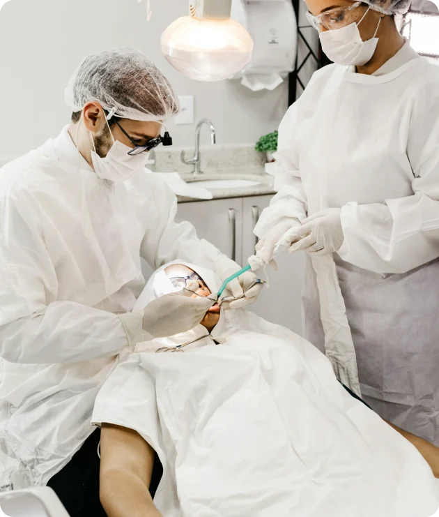 Dental technicians working with a patient in a treatment chair