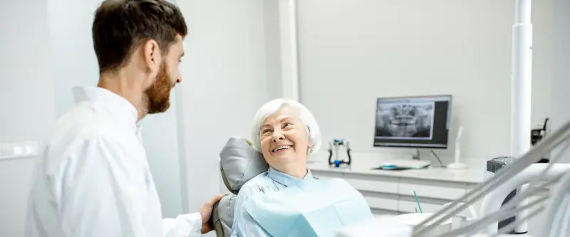 Dental technician with a smiling older patient